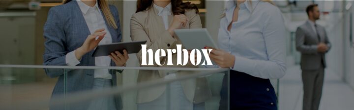Tre kvinnor i kostym håller surfplattor, text "herbox" över dem.