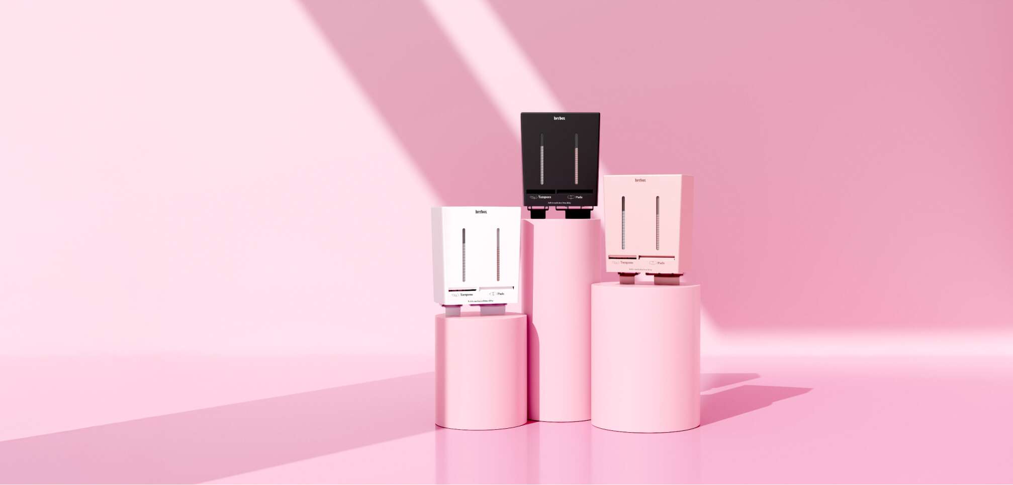 Herbox mensskyddsautomater i tre färger - vit, svart och rosa uppställda på rosa podier