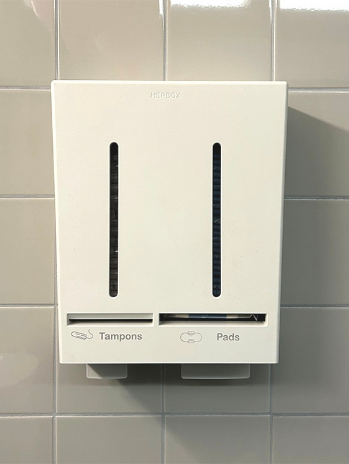 Väggmonterad vit dispenser för tamponger och bindor på kaklad vägg under Göteborg Horseshow.