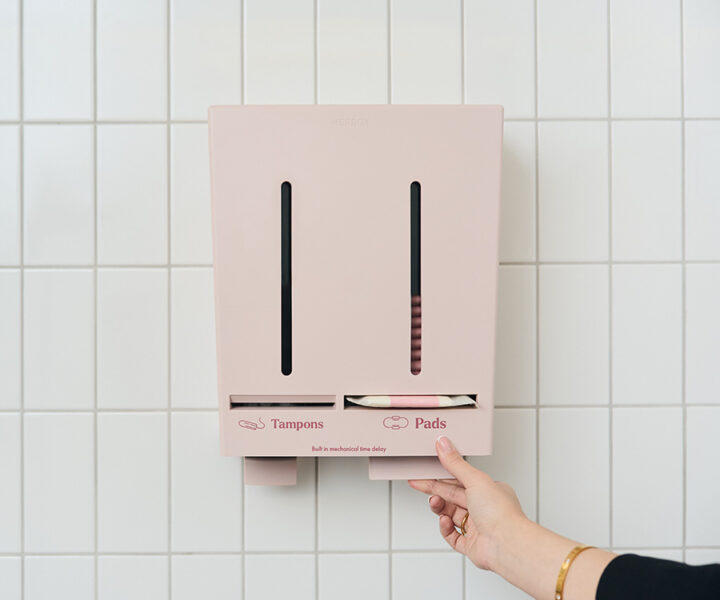 Hand tar mensskydd från Herbox dispenser på skoltoalett