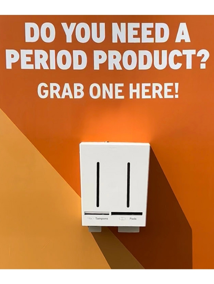 Bild på en vit combi dispenser från Herbox på en orangevägg på Roskilde festival 2024