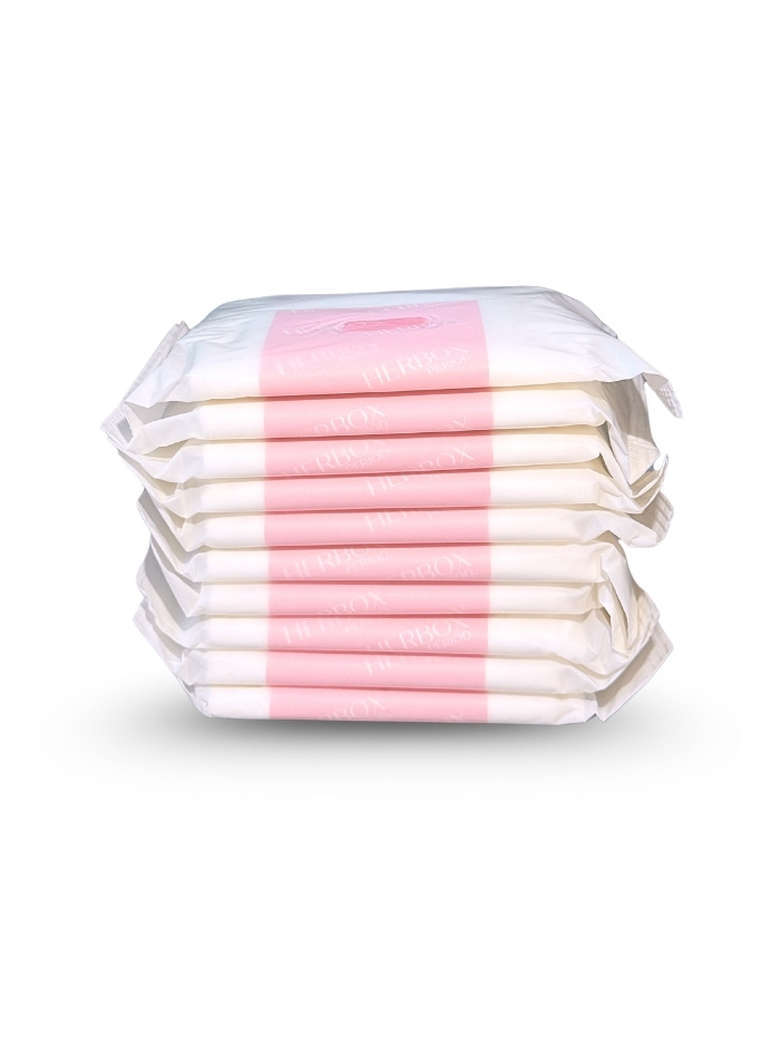 En stapel av sex vita och rosa förpackningar med sanitetsprodukter från Herbox på vit bakgrund.