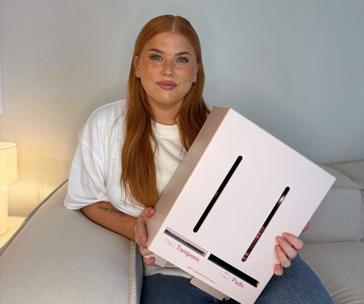 Jessica "Mithanja" sitter på en soffa och håller en rosa låda märkt med "Tampons" och "Pads".
